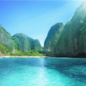 Maya Bay tropical bay with towering limestone cliffs covered in lush green vegetation.